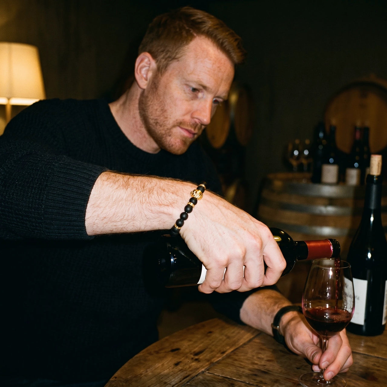 Gold Lion & Black Stones Bracelet – worn while pouring red wine | Brother & Sisters | SKU: 20712286-gold-XS-14-15, 20712286-gold-S-16-17, 20712286-gold-M-18-19, 20712286-gold-L-20-21, 20712286-gold-XL-22-23