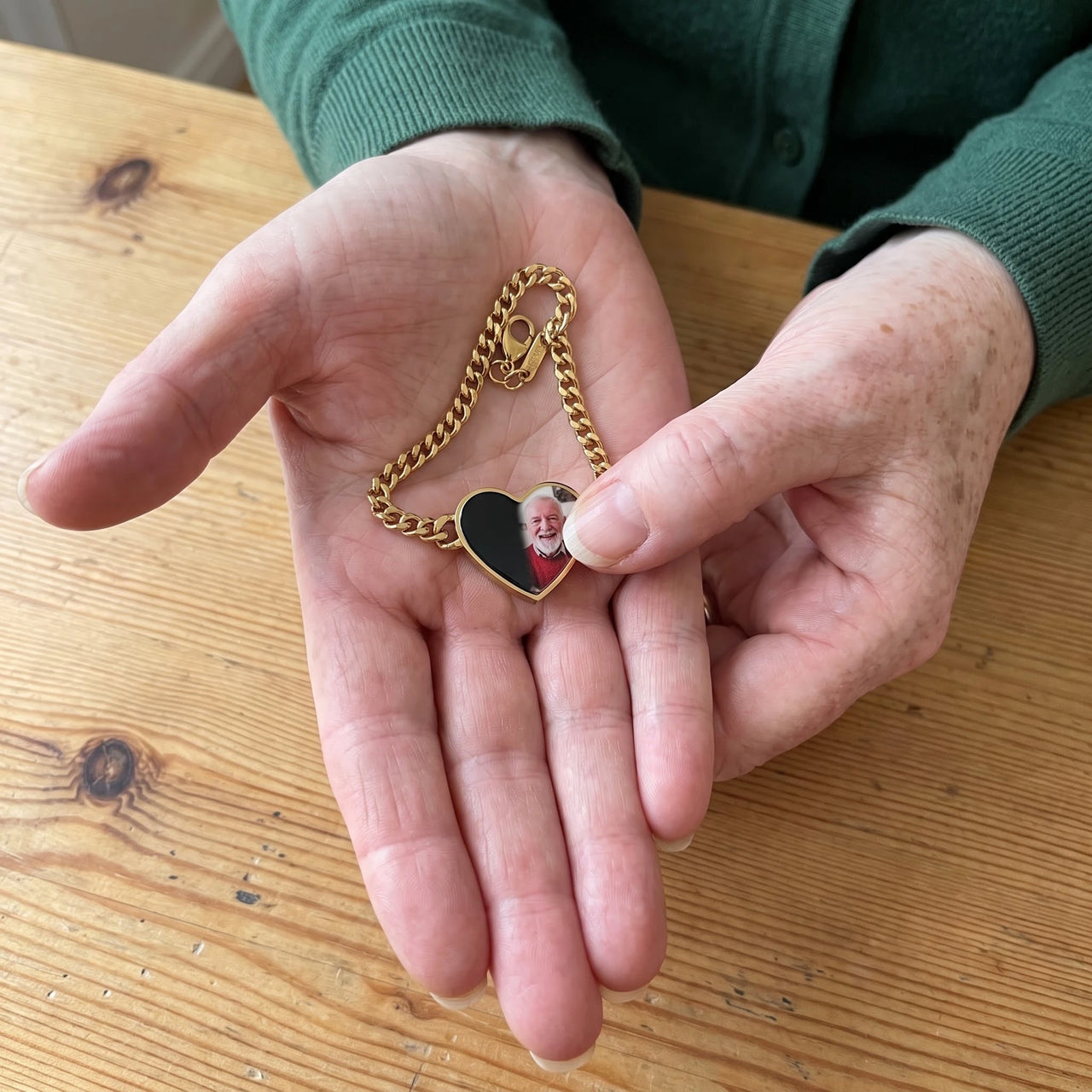 Thumb warming the gold heart bracelet plate: the hidden photo appears under the thumb while the rest stays black | SKU: TPH-HRTB-GOLD